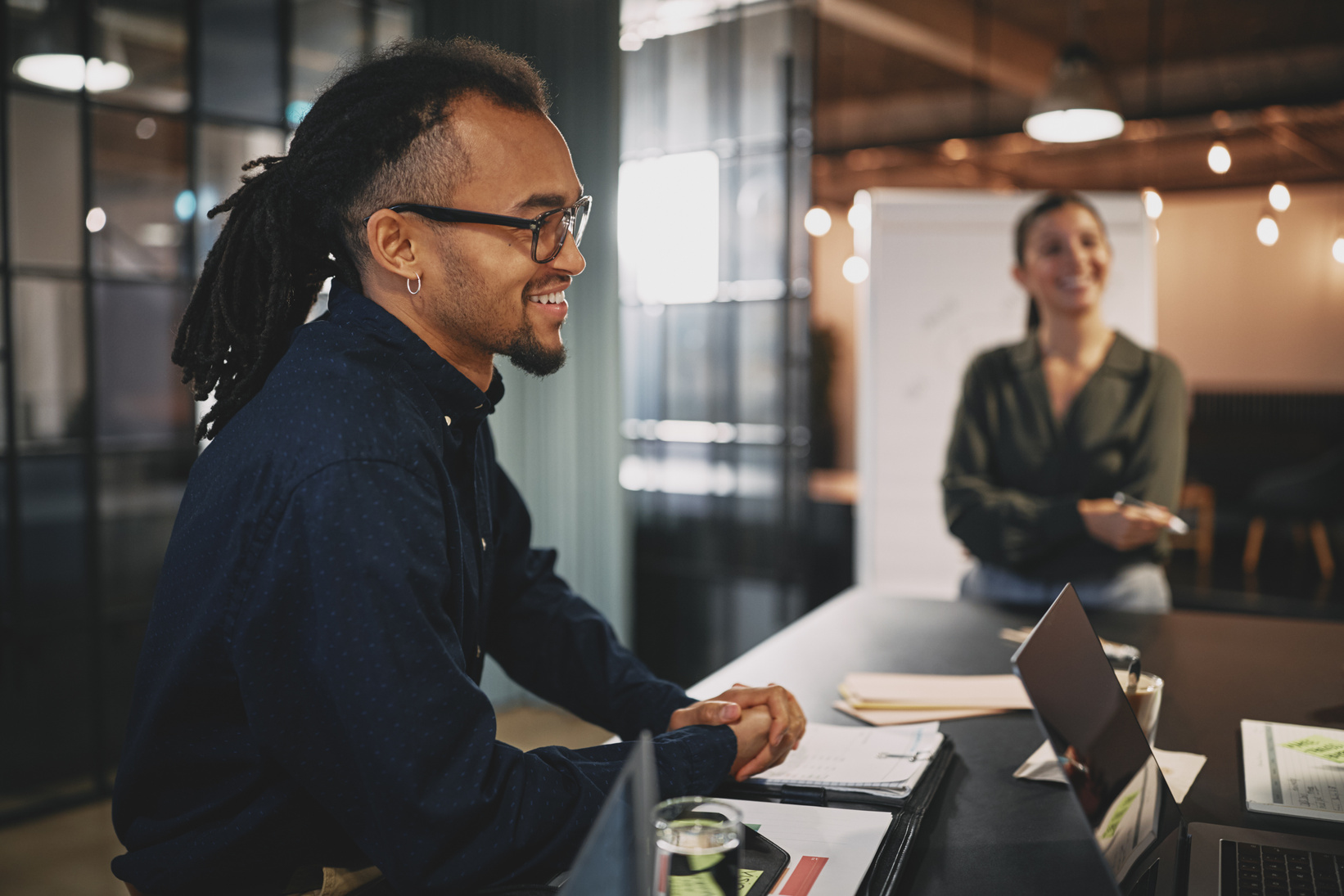 Smiling Young Businessman Sitting at an Office Table